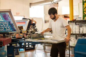 A man confidently modeling a freshly printed custom graphic tee, demonstrating the premium quality and sharp details delivered by expert Men's Affordable T-Shirt Printing Services for those seeking reliable affordable t-shirt printing and custom t shirts.