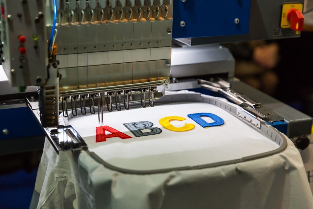 Close-up of a stitched company logo embroidered on a navy polo shirt in Little Rock, AR